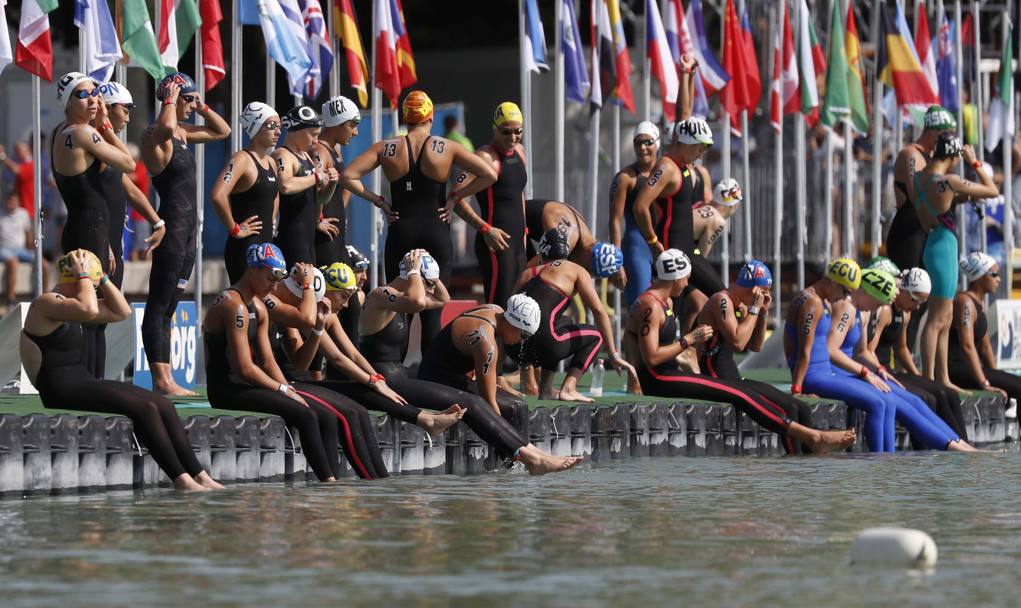 Le concorrenti della 10 km di fondo sono pronte prima della partenza, con i piedi a mollo nelle acque del lago Balaton (Reuters)